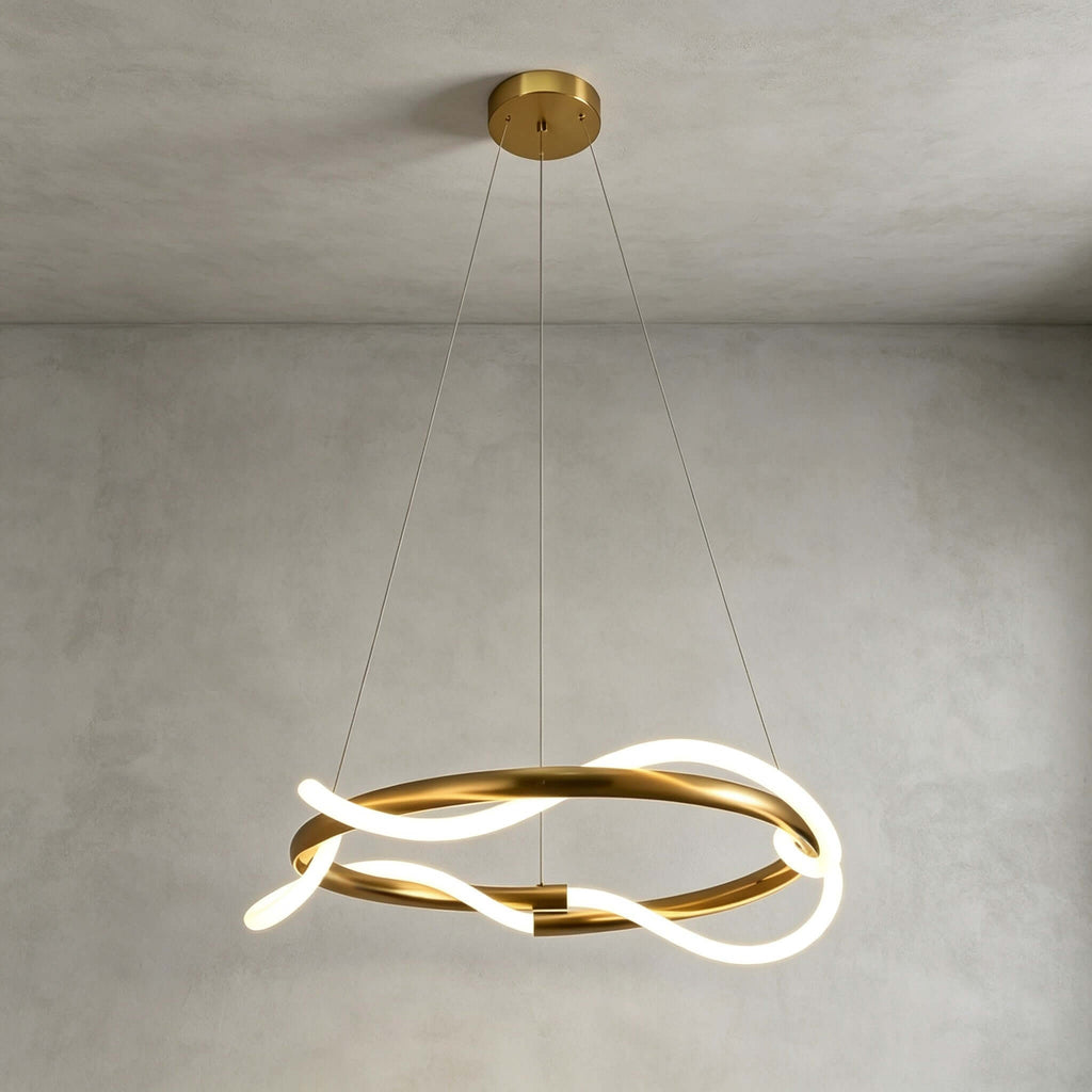 Clérachic pendant seen from slightly below, its silicone ribbon glowing as it twists around a brass ring on a grey plaster wall.