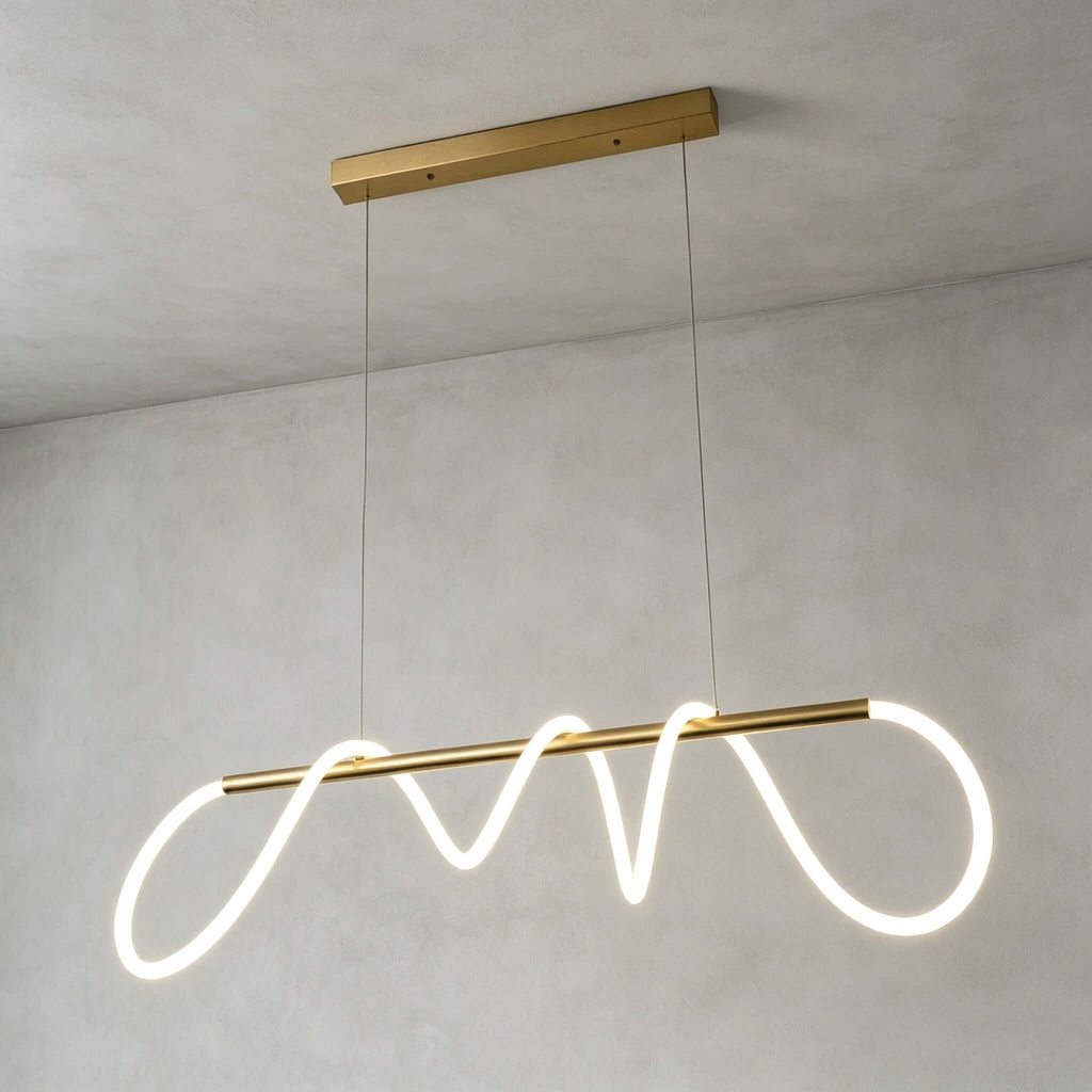 Long Clérachic linear pendant on a brass rectangular canopy, its glowing silicone ribbon looping along a slim brass bar.