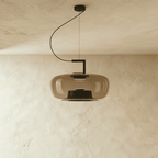 Clérachic pendant with a wide amber glass shade, black inner reflector and curved black cord, shown unlit on plaster.