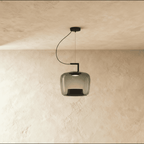 Clérachic mid-size pendant in smoky grey glass, a softly squared shade hung from a black arm, lit over limewash plaster.
