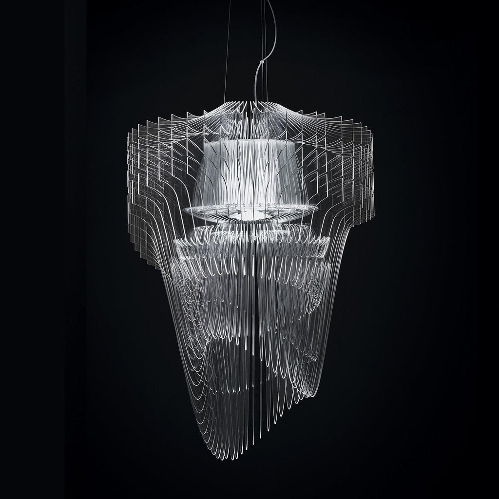 A clear fringe pendant from Clérachic seen against a black backdrop, its fins and inner shade glowing white.
