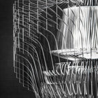 Close view of clear acrylic fins and the inner shade of a Clérachic fringe pendant, in black and white against a dark ground.