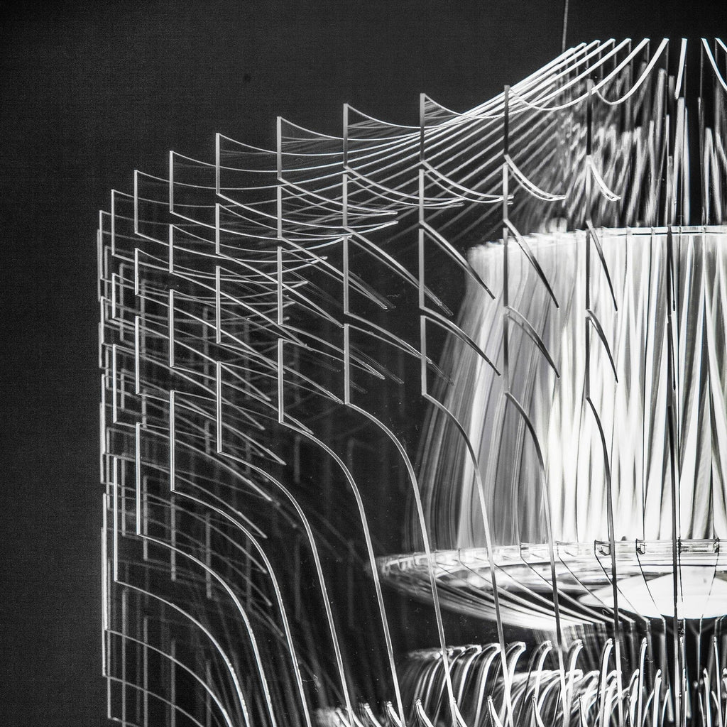 Black-and-white close view of the stacked clear fins and tiered inner shade on a Clérachic acrylic pendant.