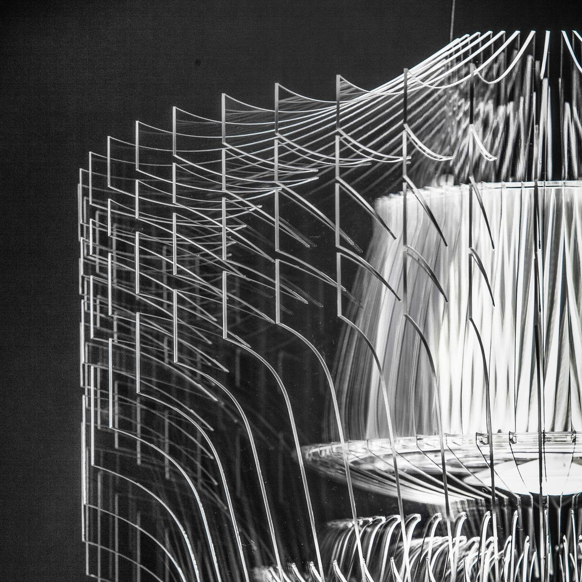 Black-and-white close view of the stacked clear fins and tiered inner shade on a Clérachic acrylic pendant.