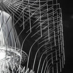Close view of the clear fins and the tiered shade underneath a Clérachic acrylic pendant, in sharp black and white.