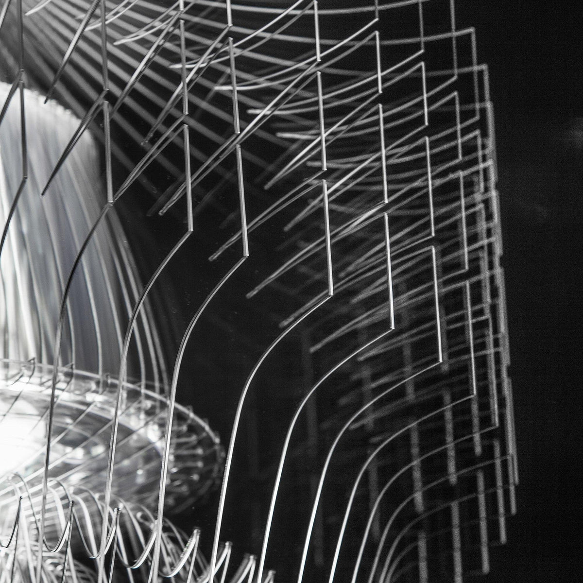 Close view of the clear fins and the tiered shade underneath a Clérachic acrylic pendant, in sharp black and white.