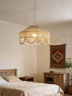 This Clérachic pendant lights a bedroom with a patterned wall hanging and a weathered wood dresser.