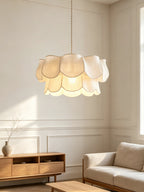 Linen petals on this Clérachic pendant glow warmly above a wooden sideboard in a panelled living room.