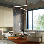 This Clérachic pendant hangs by a ribbed wall and a large window in a living room with cream sofas and an orange rug.