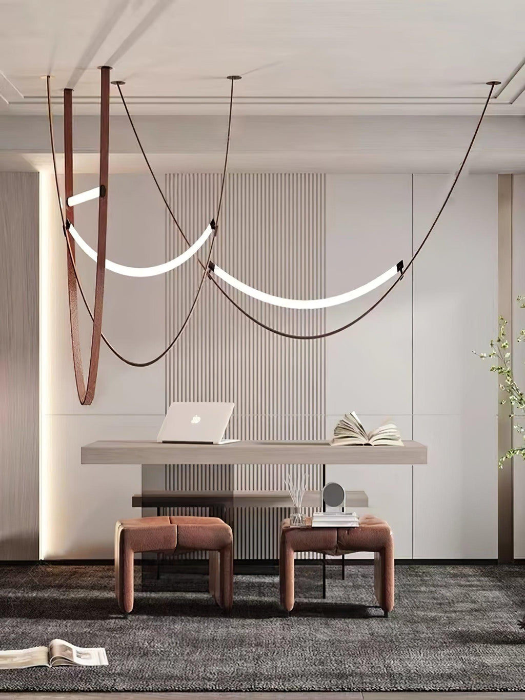 Curved light bars on leather loops hang over a pale desk and two low stools, in a room lit by this Clérachic pendant.