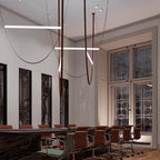 Several bars and leather loops from this Clérachic pendant hang in a high-ceilinged room with dark shutters and a long table.