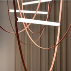 Close view of the three light bars and tan leather loops of this Clérachic pendant, framed against warm curtains.
