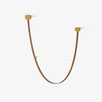 Single curved tan leather loop with a brass-capped light bar and two canopy plates, shown on this Clérachic pendant on white.