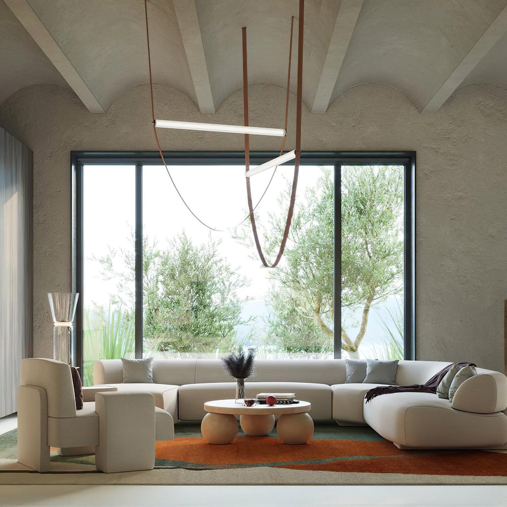 This Clérachic pendant hangs in a living room with a vaulted plaster ceiling and a big window onto olive trees.