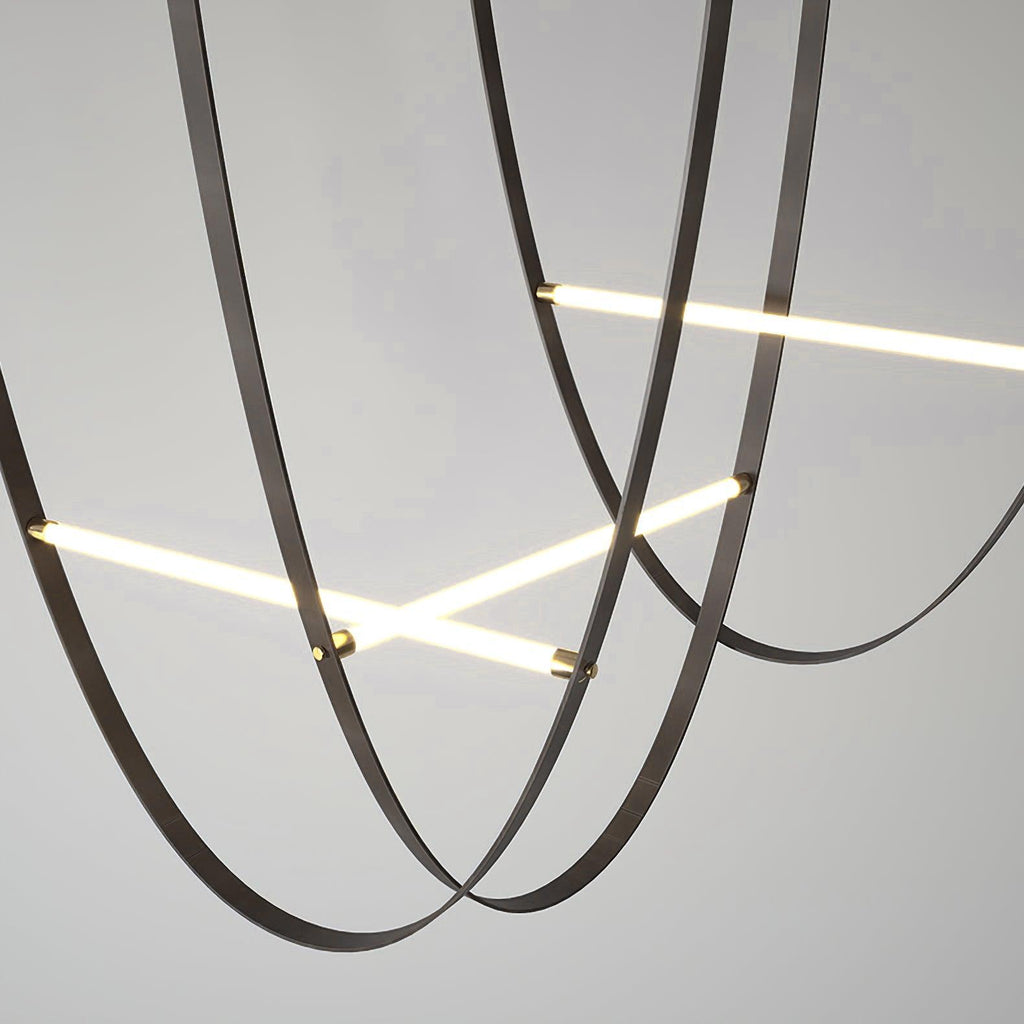 Close view of black leather loops crossing two lit bars on this Clérachic pendant, against a pale grey backdrop.