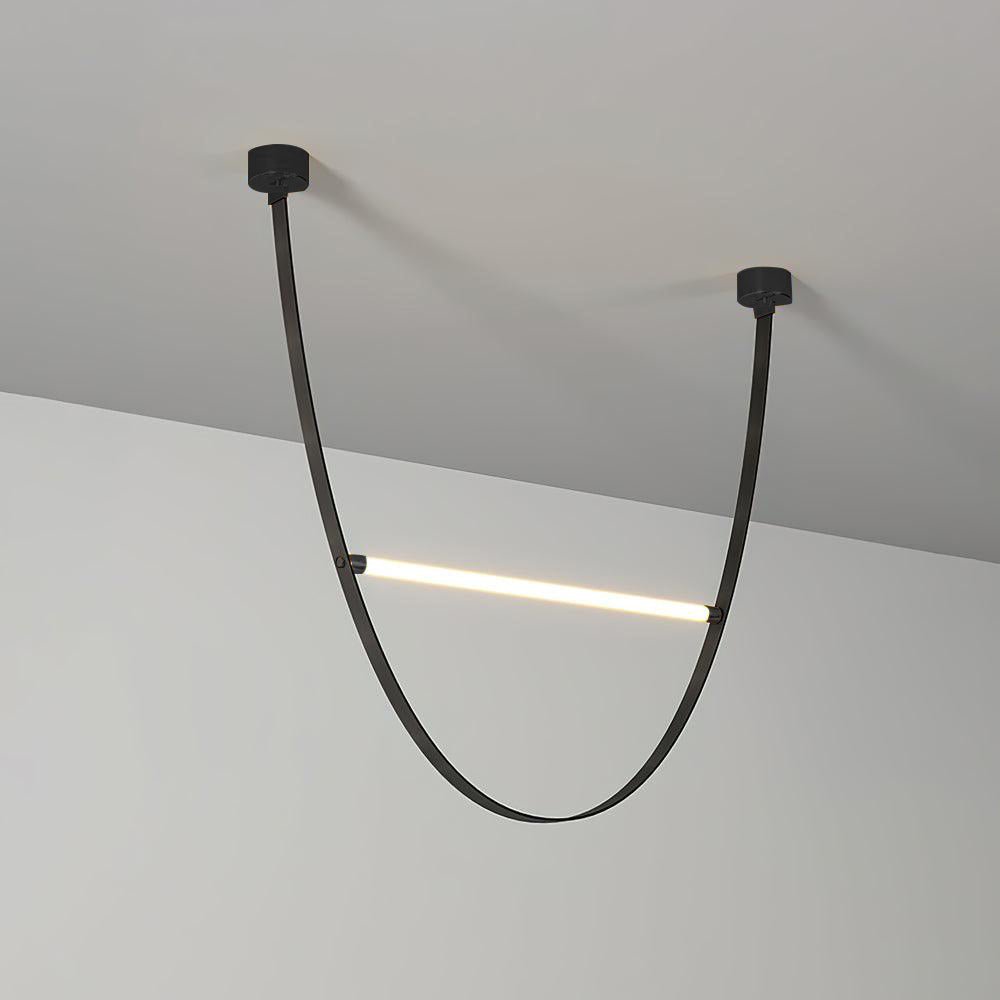 A black leather version of this Clérachic pendant, with black canopy plates and one lit bar across the loop, against a plain wall.