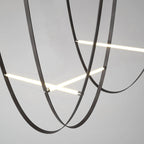 Close view of black leather loops and bars of this Clérachic pendant, seen from below against a grey background.