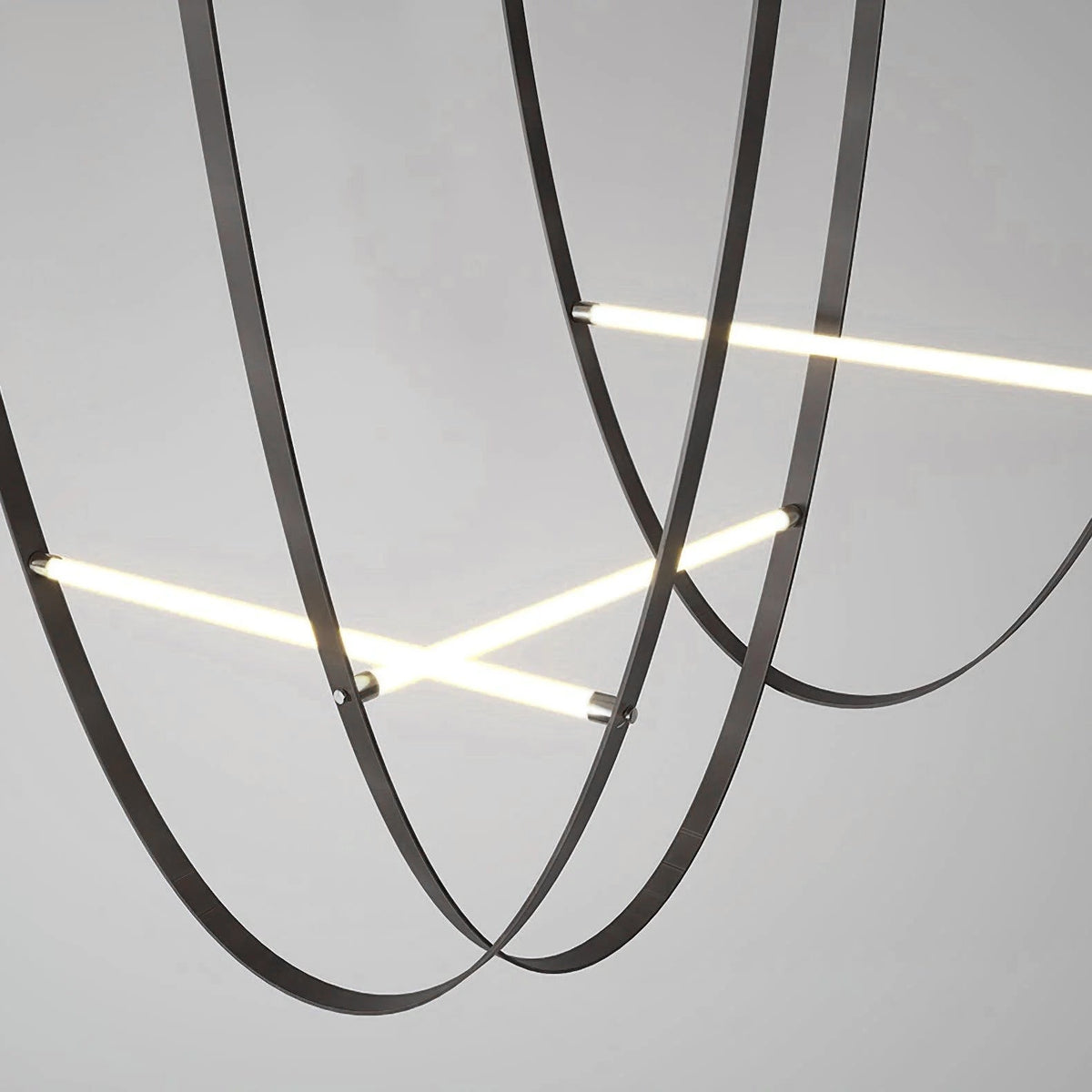Close view of black leather loops and bars of this Clérachic pendant, seen from below against a grey background.