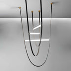 Three-loop render of this Clérachic pendant in black leather with brass canopy plates on a grey backdrop.
