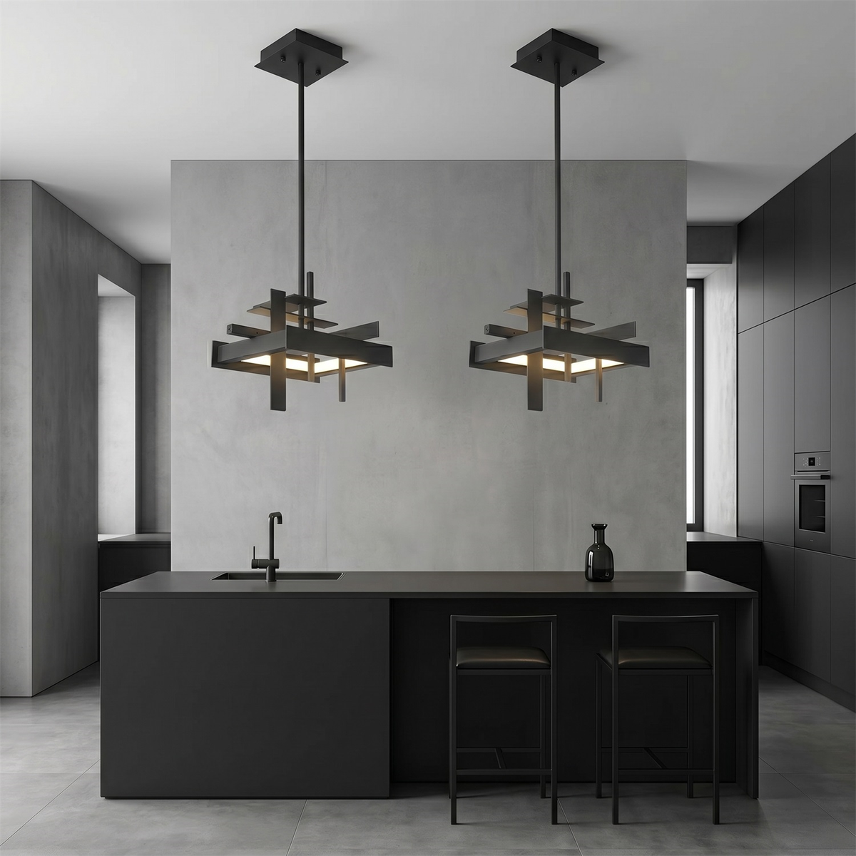 Two compact black geometric Clérachic pendants hang above a black kitchen island with bar stools, against a grey concrete-look wall.