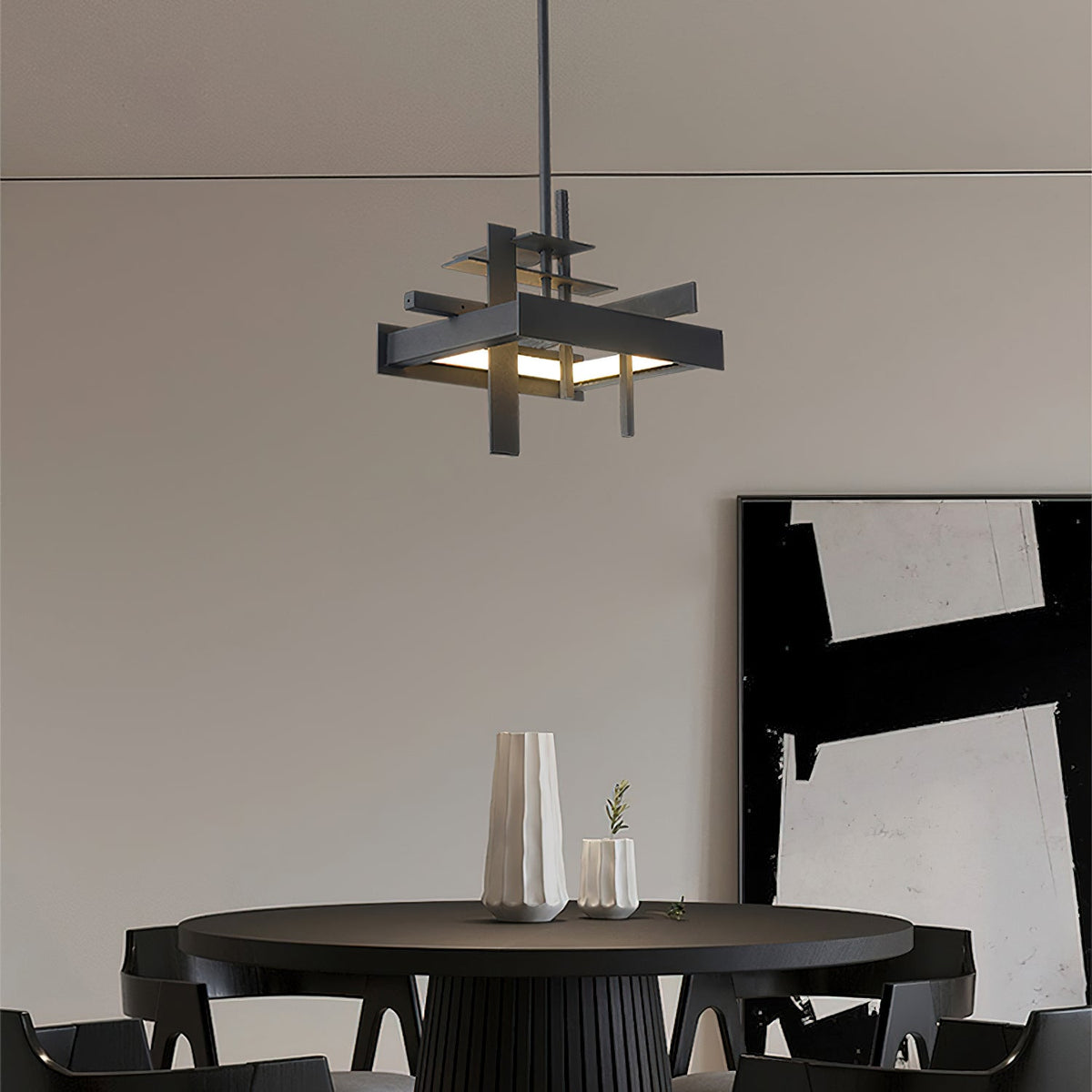 A compact black Clérachic pendant with a stacked-bar frame hangs above a round black dining table, with a large abstract print behind.