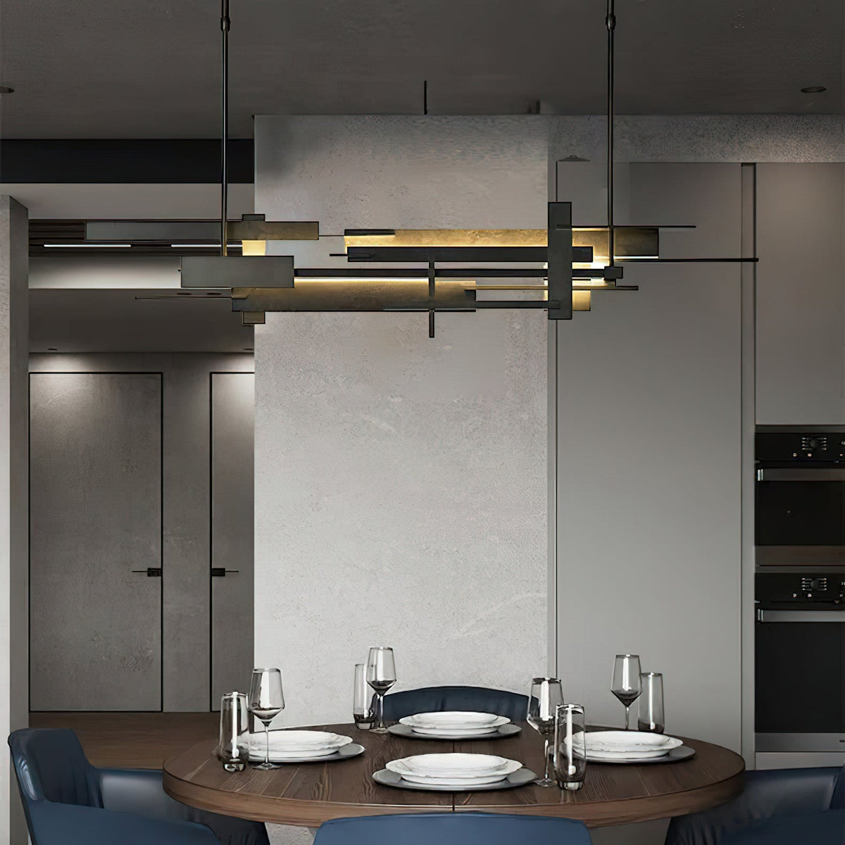A long Clérachic pendant with layered dark bars and warm light hangs over a round walnut table set with plates, glasses and blue chairs.
