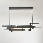 A lit linear matte black Clérachic pendant hangs from a rectangular ceiling bar, with layered bars and a light strip below.