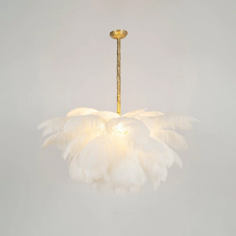 White plumes glow with soft light on this Clérachic chandelier, hung from a brass canopy and stem against a pale wall.