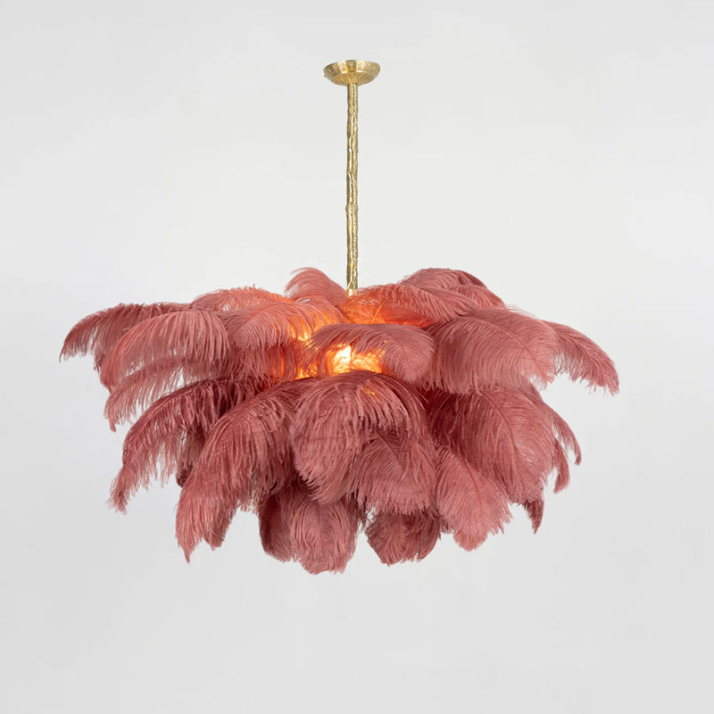 Dusty-rose feathers layer around the glowing centre of this Clérachic chandelier, hung from a brass stem.