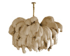 Close front view of a Clérachic chandelier in warm beige feathers, the plumes curling at the outer edge.