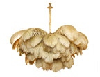 A Clérachic chandelier in gold-toned feathers hangs from a carved brass stem, shown whole on a white backdrop.