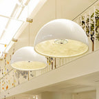 Two large Clérachic white dome pendant lights hung beside a mezzanine balustrade, lit warm from within.
