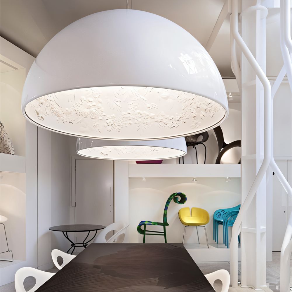 Large Clérachic glossy white dome pendant over a dark dining table, its interior moulded with a floral garland.