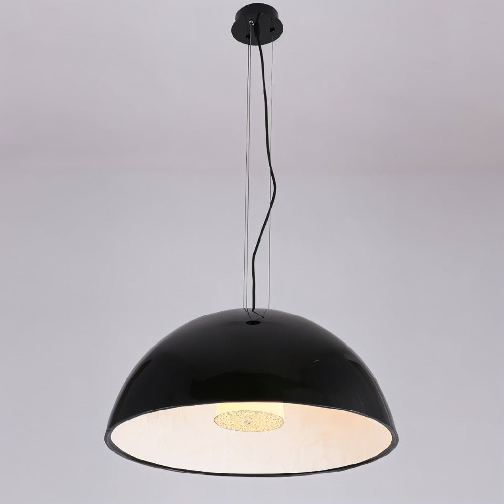 Clérachic glossy black dome pendant light hung on fine wires and a black cord, glowing warm inside, on grey.