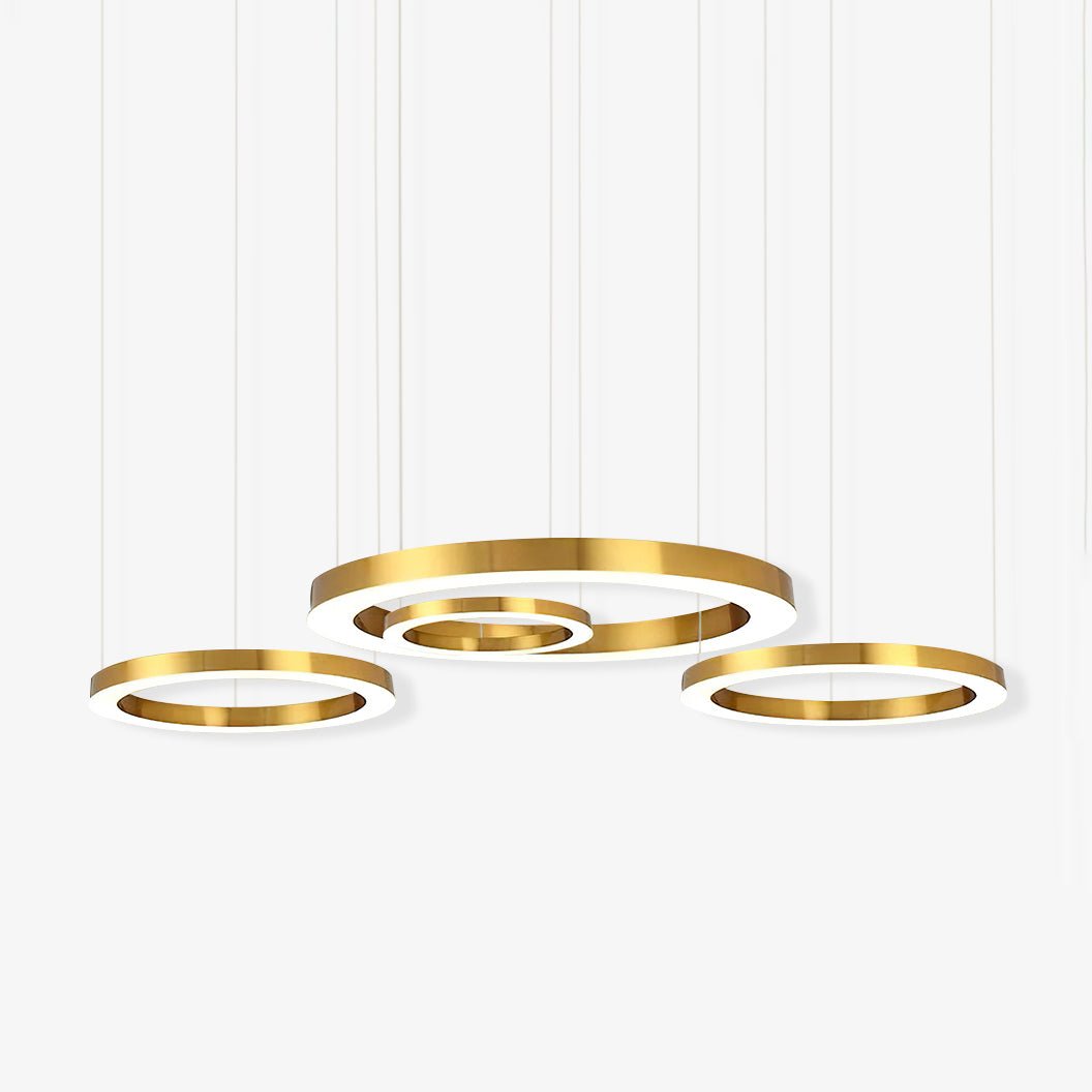 Four gold rings of different diameters hang at staggered heights on thin cables against a white backdrop, on this Clérachic ring pendant.