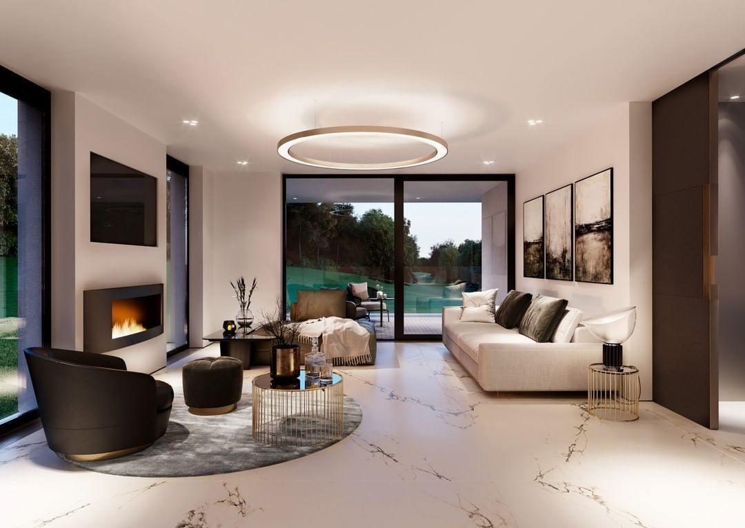 One lit ring pendant hangs in the centre of a long white living room with a marble floor and garden doors, in a Clérachic ring pendant style.