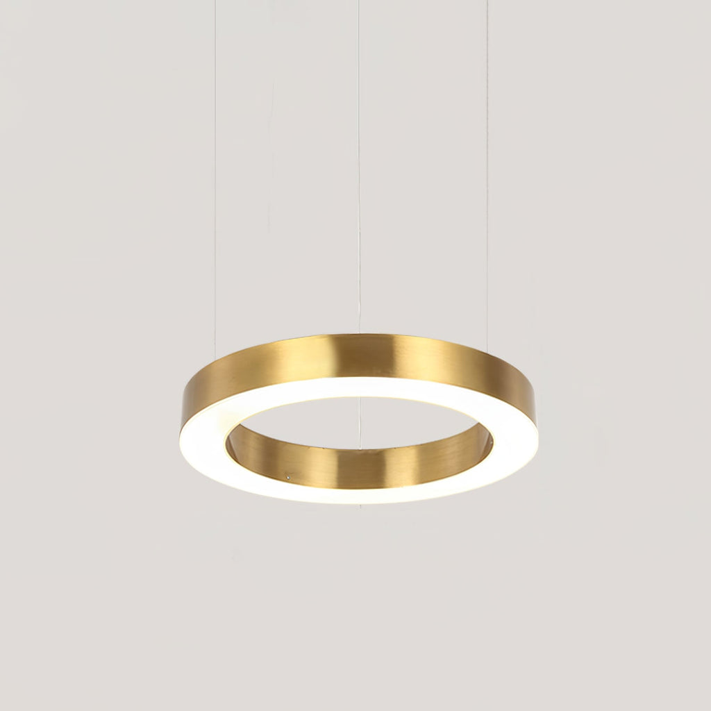 A single brushed gold ring pendant lit from inside, hanging on thin cables against a pale grey backdrop, a Clérachic ring light.