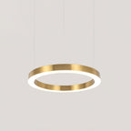 A single brushed gold ring with a white lit underside hangs on thin cables against pale grey, a mid-size Clérachic ring pendant.