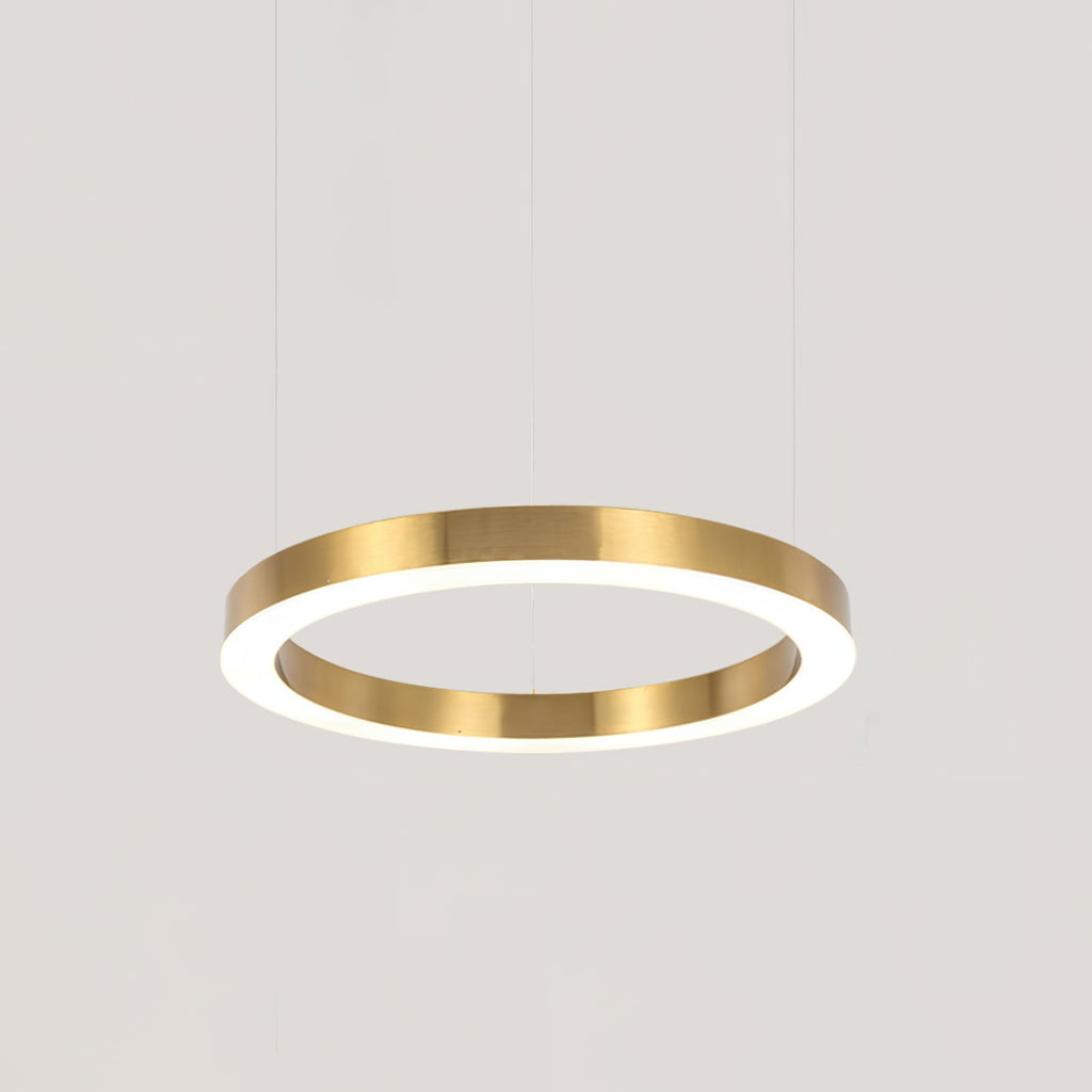 A single gold ring hangs on three fine cables against a plain pale grey backdrop, its white diffuser glowing, from Clérachic.