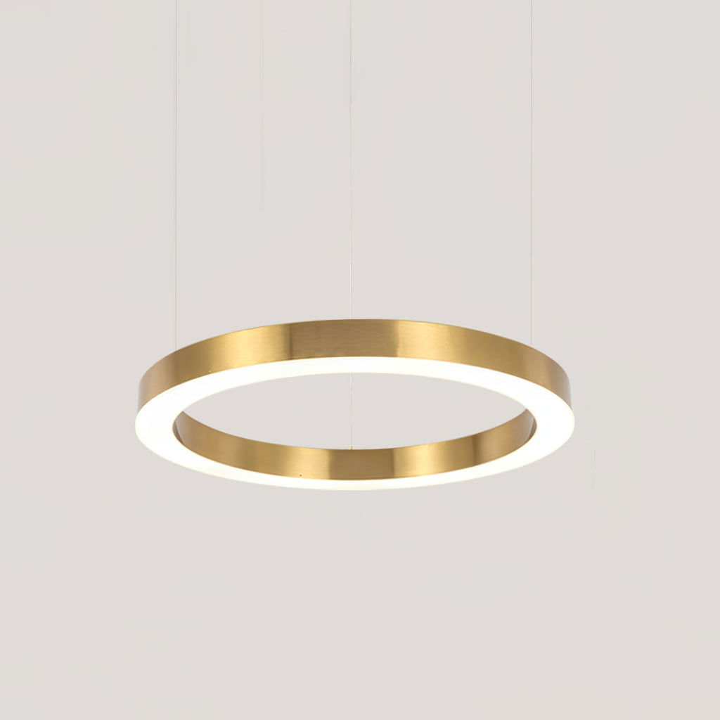 A larger single gold ring with a glowing white diffuser hangs on cables against a pale grey backdrop, shown as this Clérachic pendant.