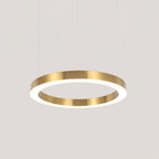 A larger single gold ring with a glowing white diffuser hangs on cables against a pale grey backdrop, shown as this Clérachic pendant.