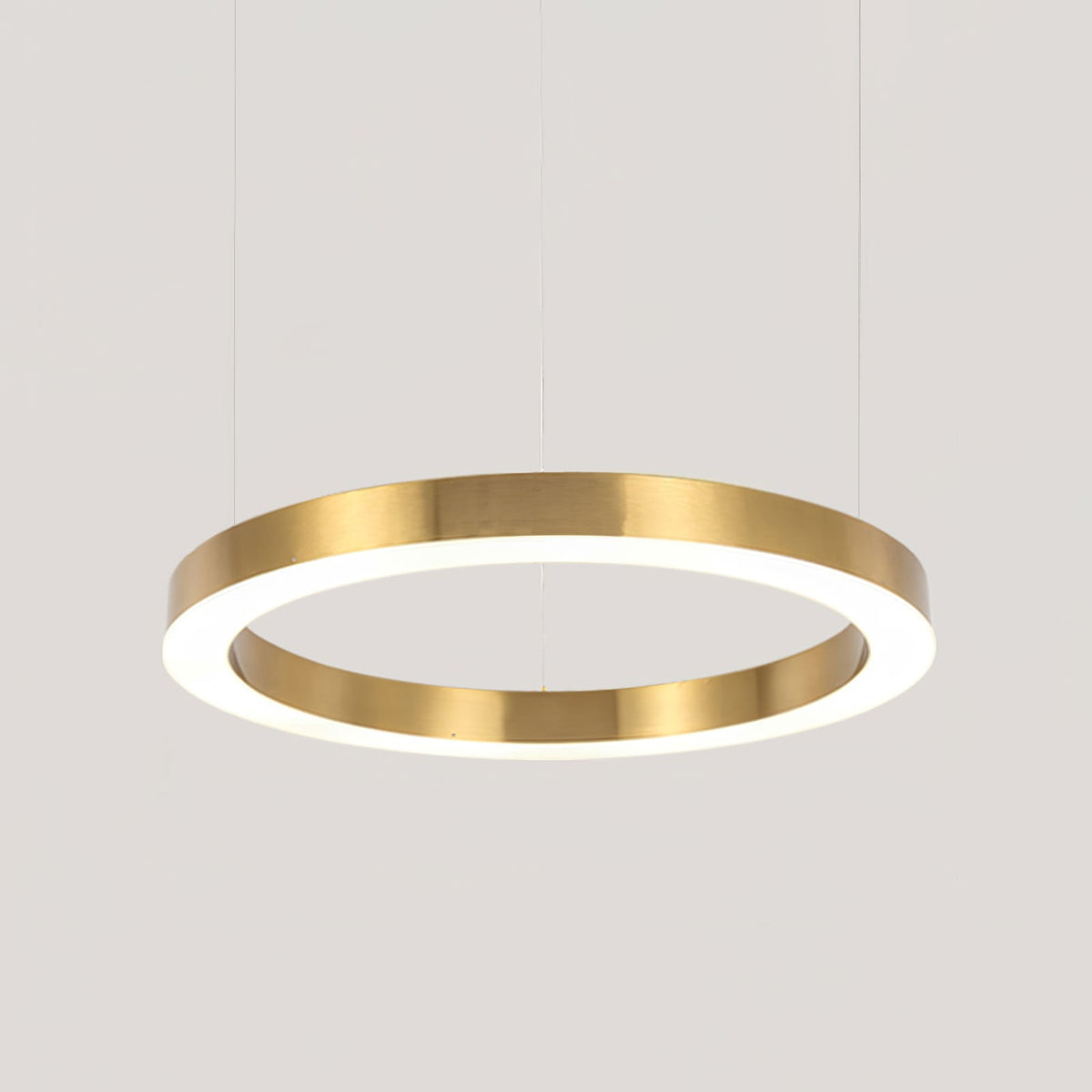 The largest single gold ring in close crop, its brushed edge and white diffuser lit, on pale grey, from Clérachic.