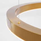 Close view of a brushed gold ring with a brass cable gripper on top and the white light strip beneath, on this Clérachic pendant.