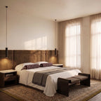 Clérachic pair of slim black cylinder pendant lights hanging either side of a velvet headboard as bedside lighting.