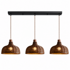 A three-light linear fixture from this Clérachic pendant shows three rounded rattan basket shades on a plain backdrop.