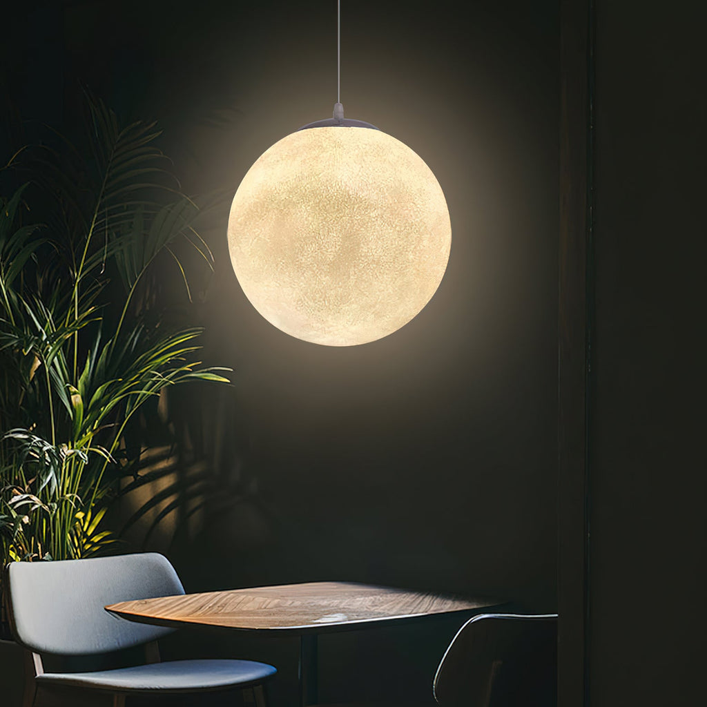 Beside a leafy plant and a small round wooden table, one Clérachic sphere casts a warm halo across a dark wall.