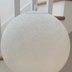 Close view of the fine, web-like fibre texture on a large white Clérachic sphere, with the white canopy and cord at the top.