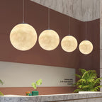 Four Clérachic spheres in descending sizes hang in a row above a marble reception counter against a terracotta wall.