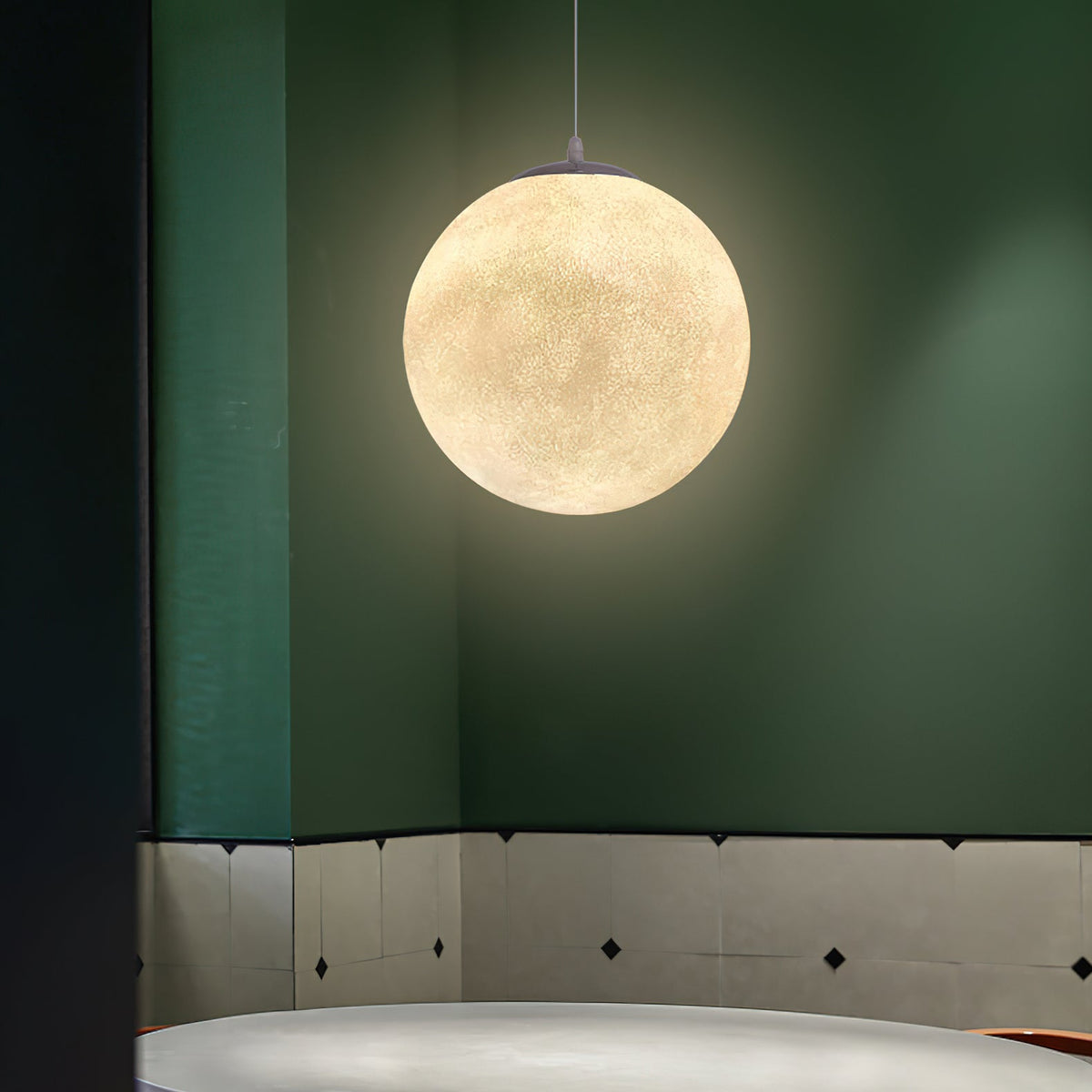 A single lit Clérachic sphere hangs against a deep green wall with a pale tiled lower section.