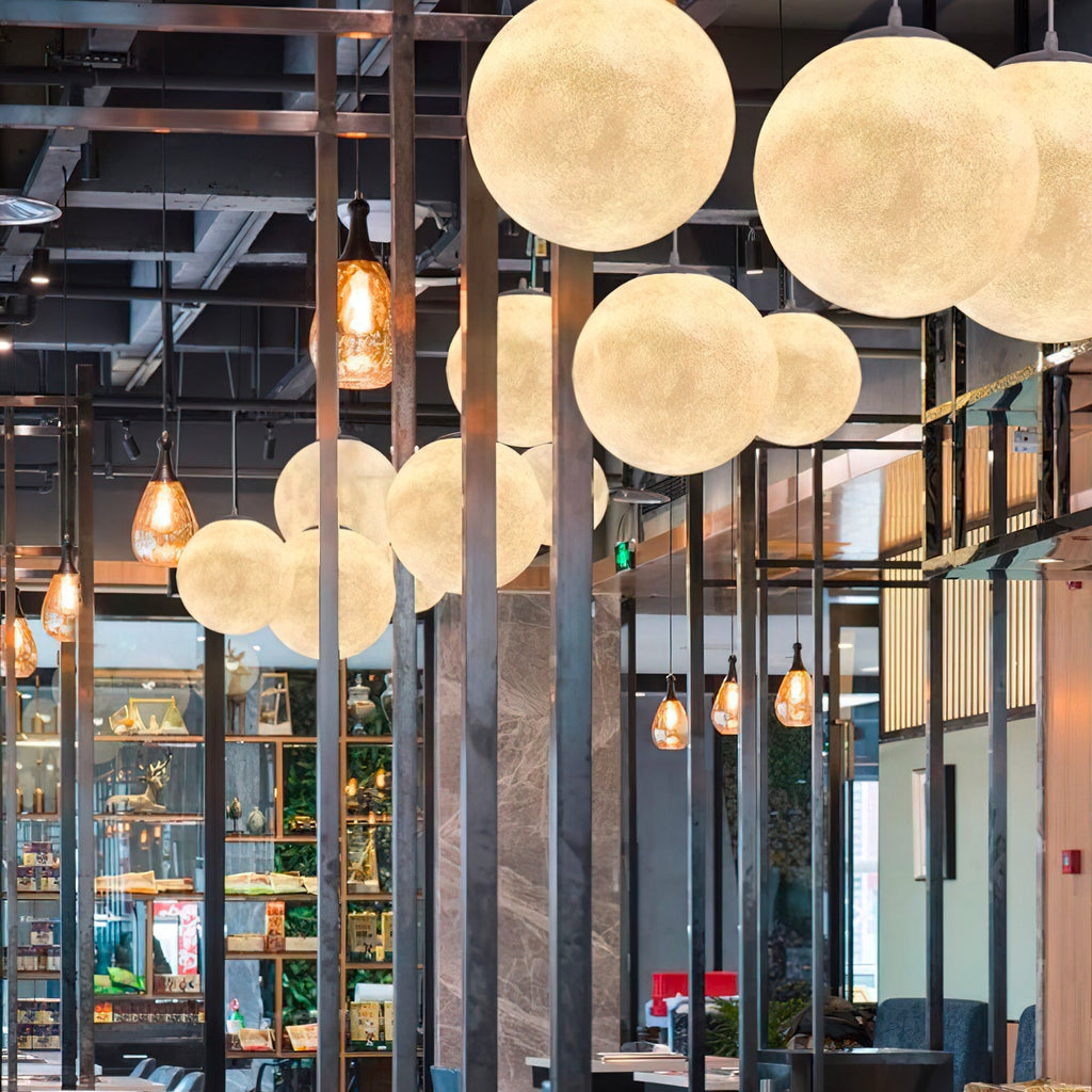 Large Clérachic spheres hang close together in front of dark steel columns, amber filament pendants and shelves of glassware.